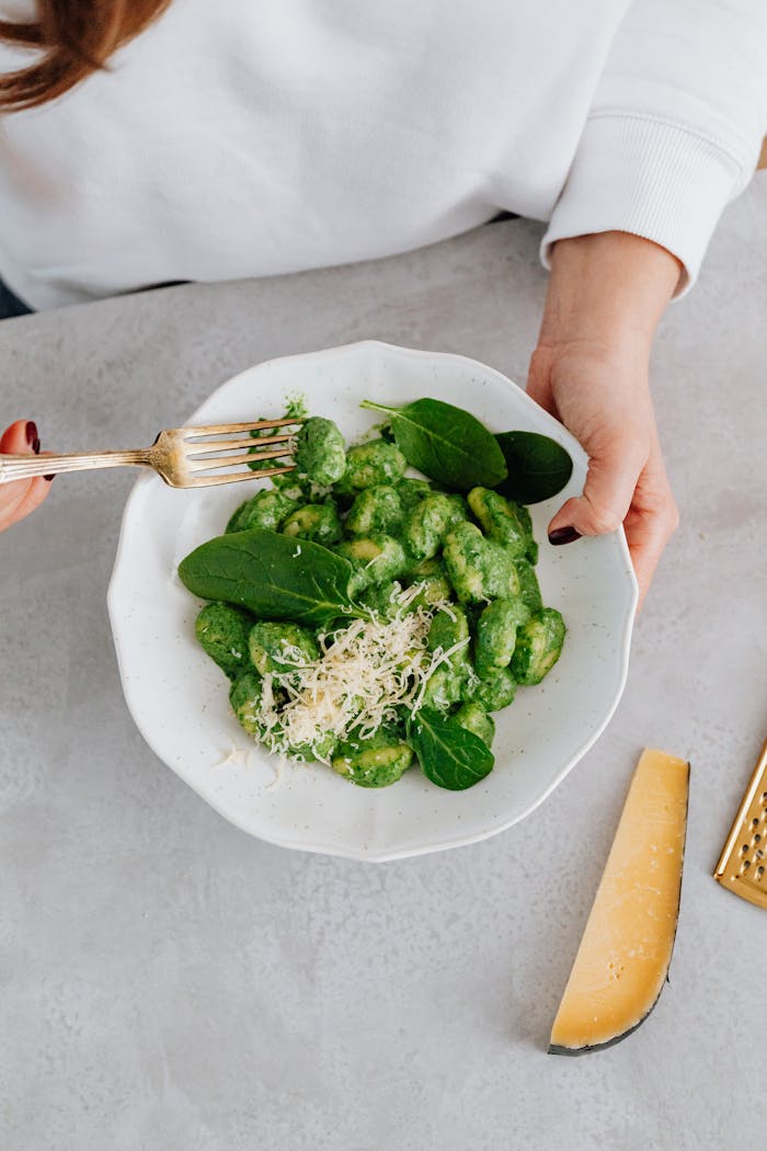 Delicious spinach gnocchi with parmesan cheese, perfect for a healthy vegetarian meal.